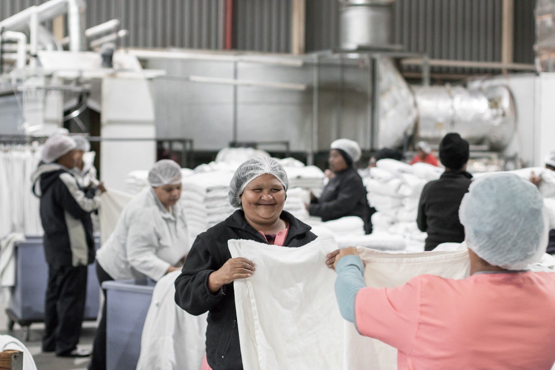 Coral Clean team members handling professionally laundered textiles